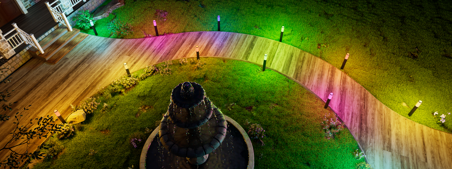 Color changing smart pathway lights outlining curved garden walkway at night