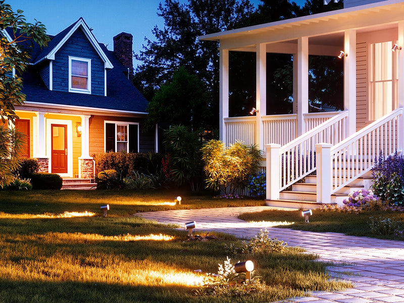 Outdoor spotlights highlighting front yard lawn and walkway for safe and decorative landscape lighting